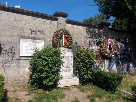 Monumento ai caduti di Campo Giuriati, con decorazioni floreali e scritte su un muro di cinta.