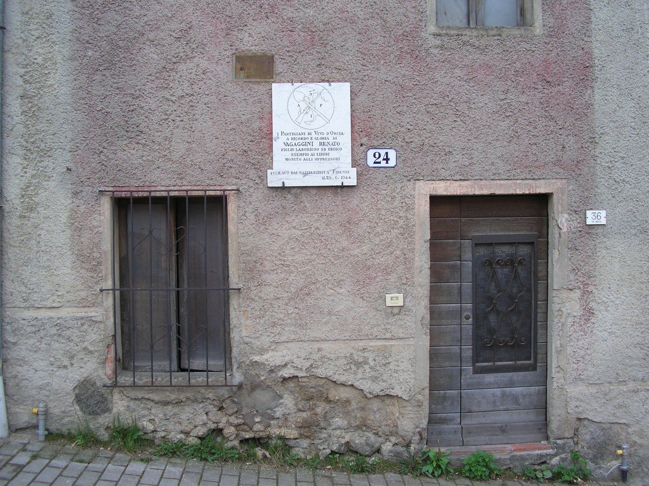 Lapide commemorativa a Vagaggini su una parete di un edificio storico.
