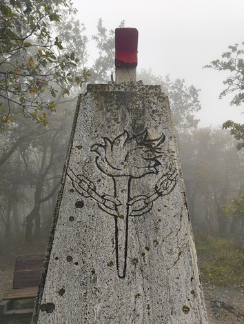 Monumento alla Stella Rossa, dedicato ai caduti di Monte Sole, immerso in una nebbiosa atmosfera boschiva.