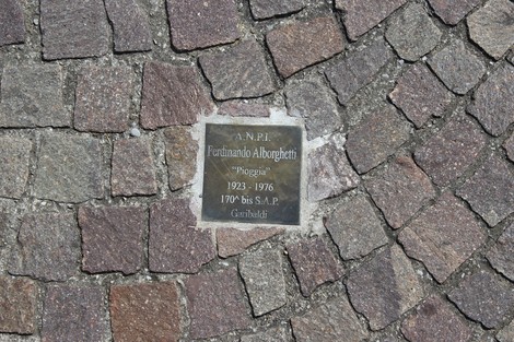 Pietra d'inciampo dedicata a Fortuniano Alborghetti, partigiano, incastonata nel pavimento di una strada.