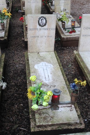 Tombe dedicate ai caduti per la Libertà, con fiori e candele in un ambiente commemorativo.