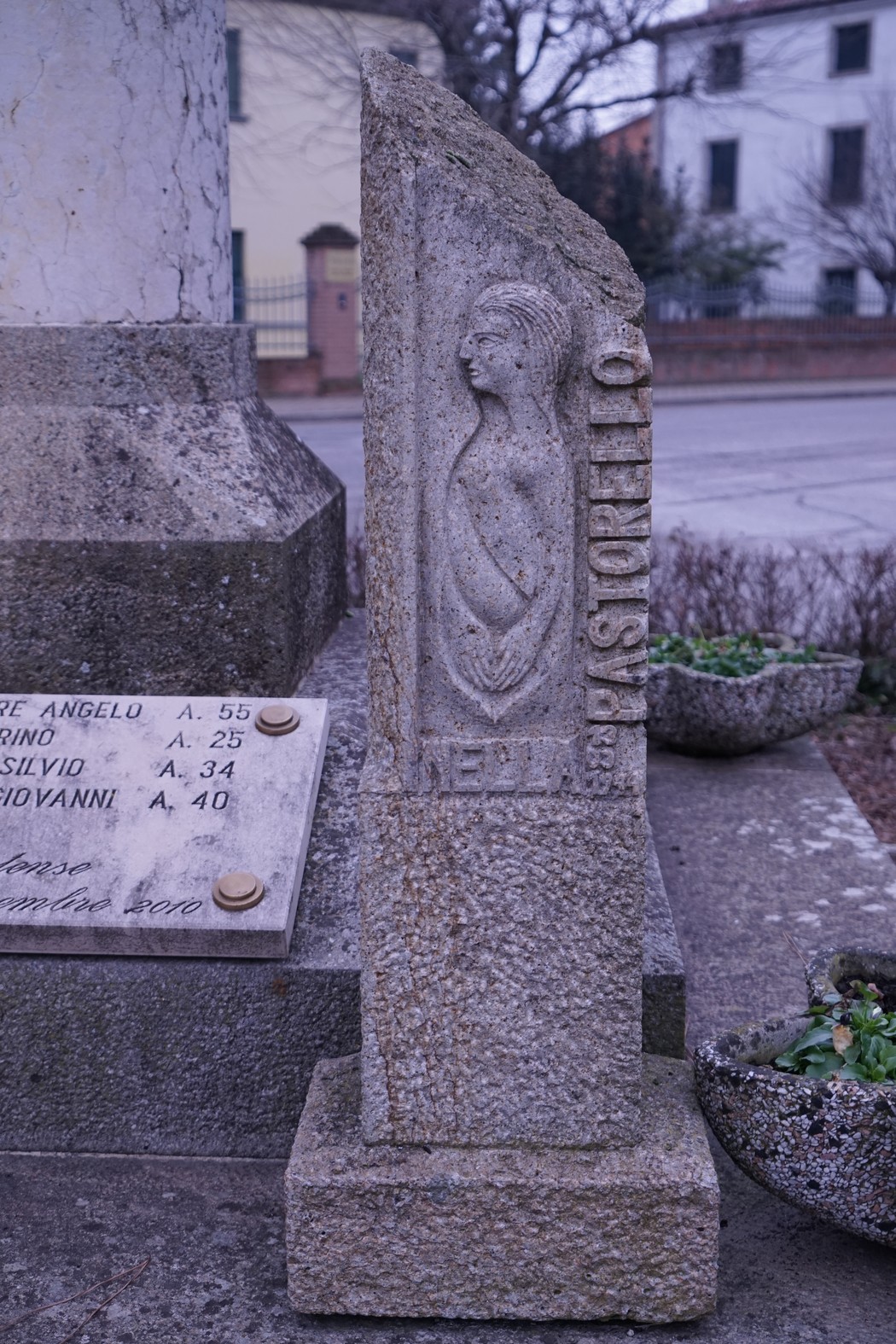 Monumento commemorativo dedicato ai caduti di Villa Estense, con sculture in pietra e dettagli storici.