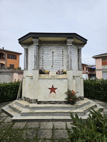 Monumento ai Caduti di Casaltone, monumento commemorativo decorato con fiori e una stella rossa.
