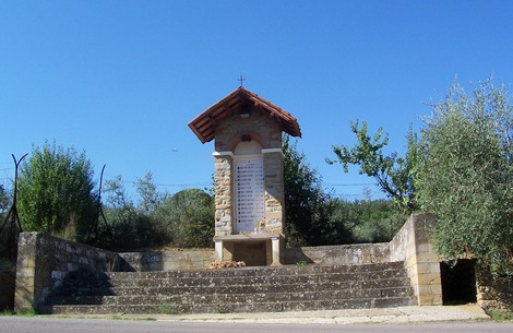 Monumento della Fontaccia, struttura in pietra con tetto in legno, immerso nel verde e circondato da alberi.