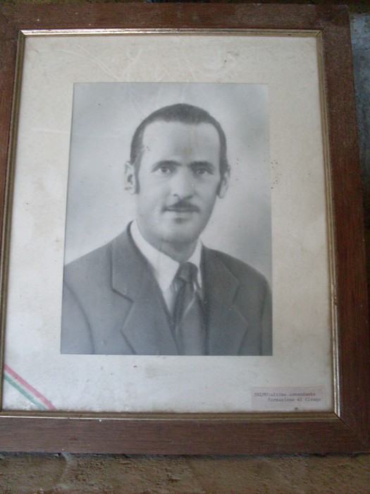 Ritratto in bianco e nero di un uomo, incorniciato in una foto storica.