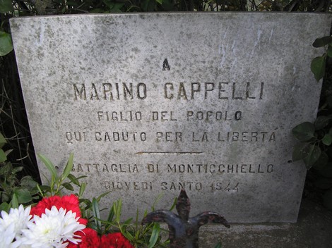 Cippo commemorativo dedicato a Marino Cappelli, eroe della libertà, decorato con fiori.