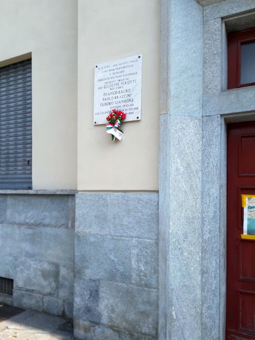 Lapide commemorativa per i martiri del Comitato Militare Regionale Piemontese, decorata con un omaggio floreale.
