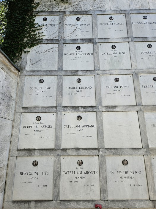 Monumento ai Caduti Partigiani, un memoriale in pietra con targhe commemorative e nomi di caduti in guerra.