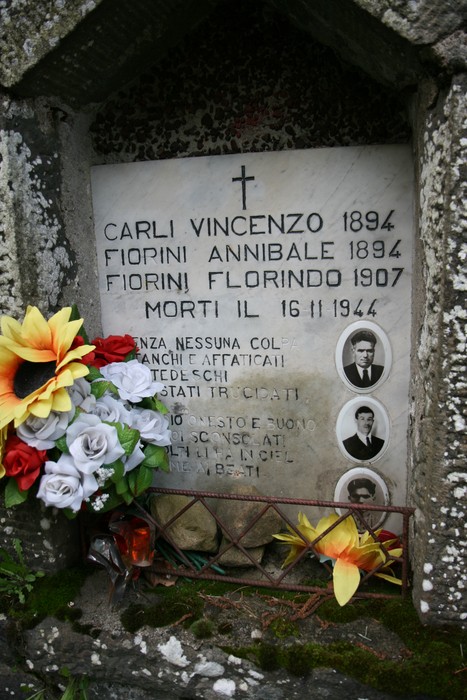 Tabernacolo commemorativo dedicate a Carli e Fiorini, con iscrizioni e adornato di fiori.