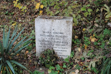 Cippo commemorativo per le vittime del bombardamento, immerso nella vegetazione circostante.