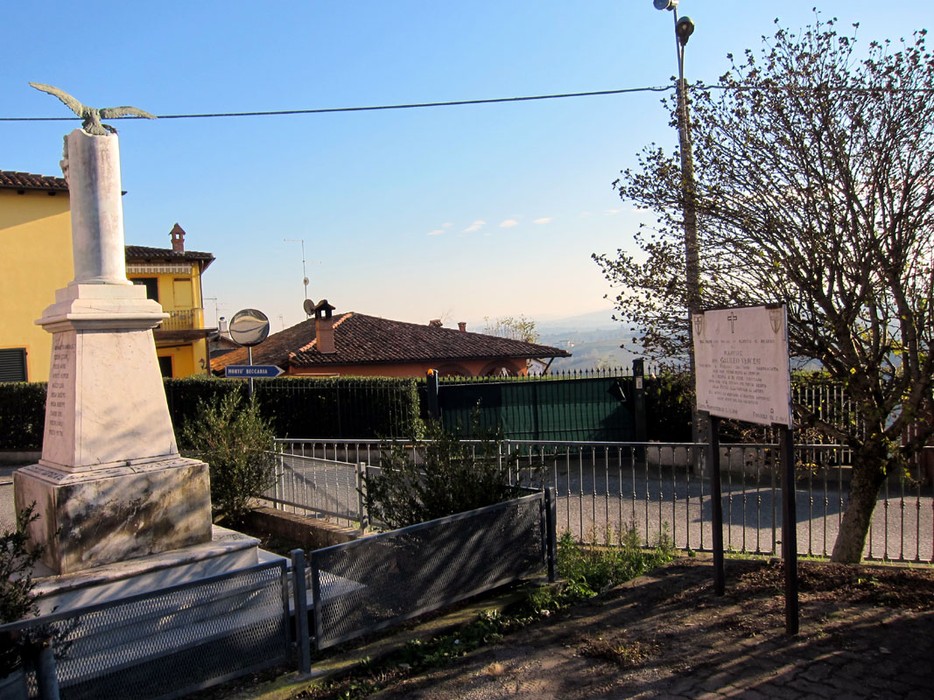 Monumento a Vercesi con vista panoramica, circondato da alberi e abitazioni in un contesto tranquillo.