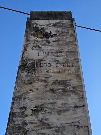 Monumento ai Caduti di Limone, struttura alta e maestosa sotto un cielo azzurro.