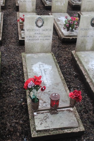 Tombe con fiori e lumini dedicati ai caduti per la Libertà, in un contesto di commemorazione e rispetto.
