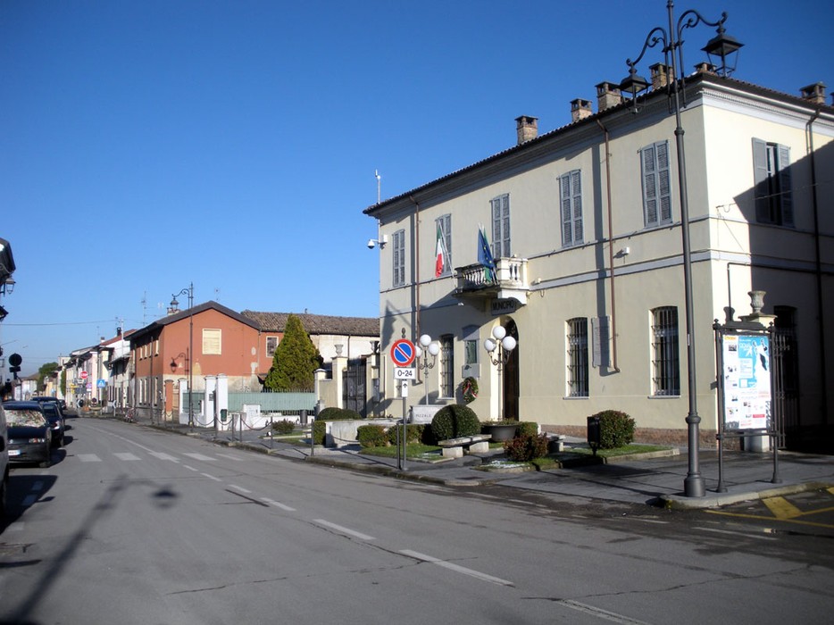 Veduta della lapide commemorativa ai caduti di Pizzale, con edifici e strade circostanti.