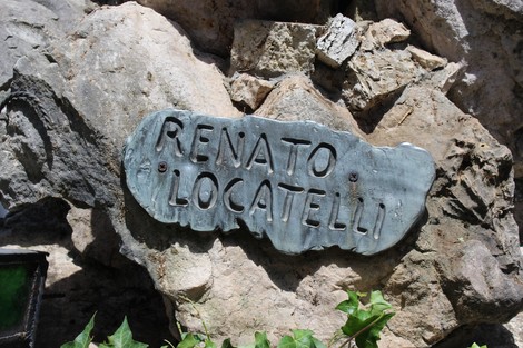 Monumento a Locatelli, incastonato tra rocce con una placca commemorativa in evidenza.