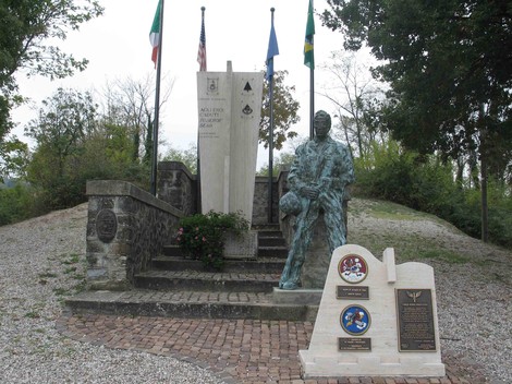 Monumento al Soldato americano, con statua e pannelli commemorativi incastonati in un ambiente verde e tranquillo.
