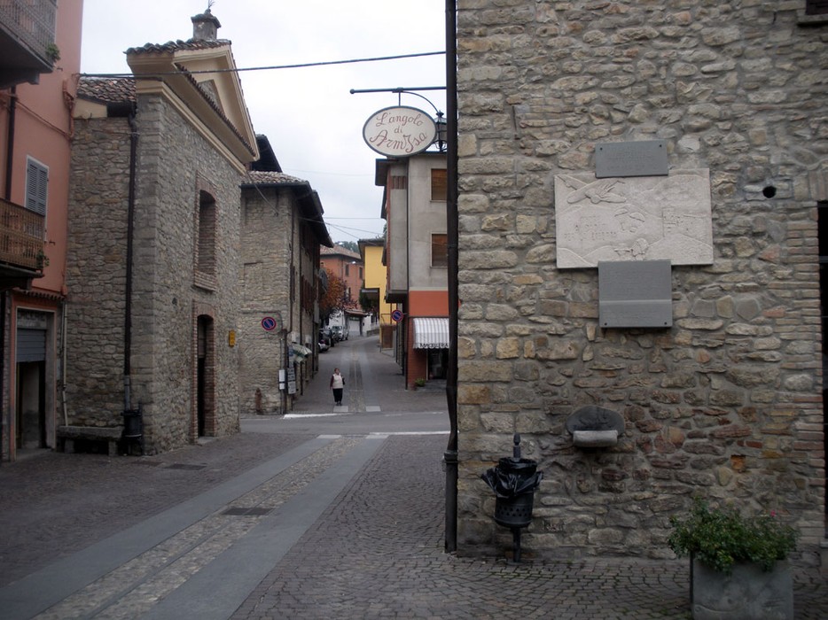 Lapide commemorativa dedicata agli avieri alleati in una tranquilla via di un comune storico.