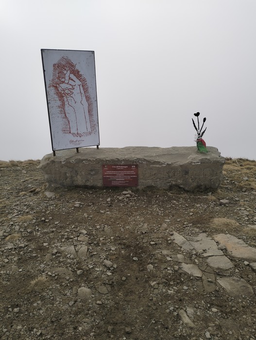 Monumento "Fiore del partigiano" con una mano che stringe un fiore, simbolo di resistenza e libertà.