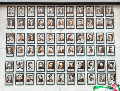 Sacrario dei caduti partigiani con una serie di ritratti in bianco e nero di uomini e donne.