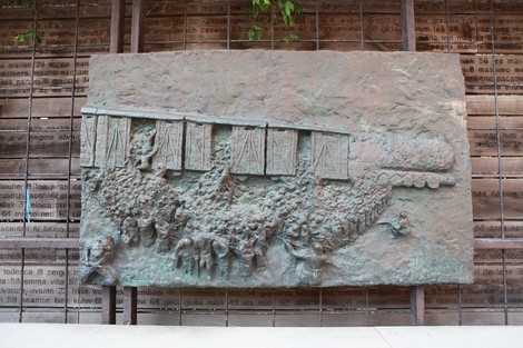 Scultura che rappresenta una folla davanti a un treno, simboleggiando l'ultimo viaggio e la memoria storica.