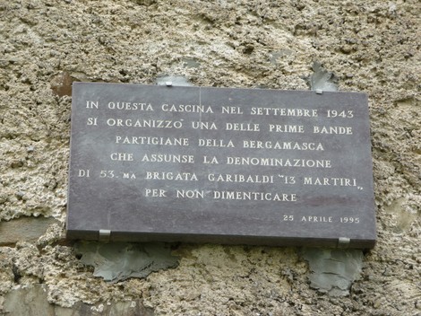 Lapide commemorativa della 53a brigata Garibaldi, dedicata alla memoria dei partigiani. Resti storici in un contesto rurale.
