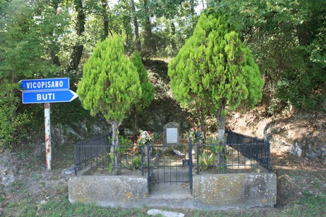 Cippo commemorativo della famiglia Petri, circondato da alberi e fiori, situato lungo la strada per Vicopisano.