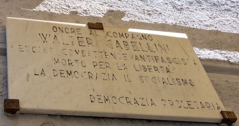 Lapide commemorativa dedicata a Walter Gabellini, antifascista e martire della libertà, in un contesto storico.