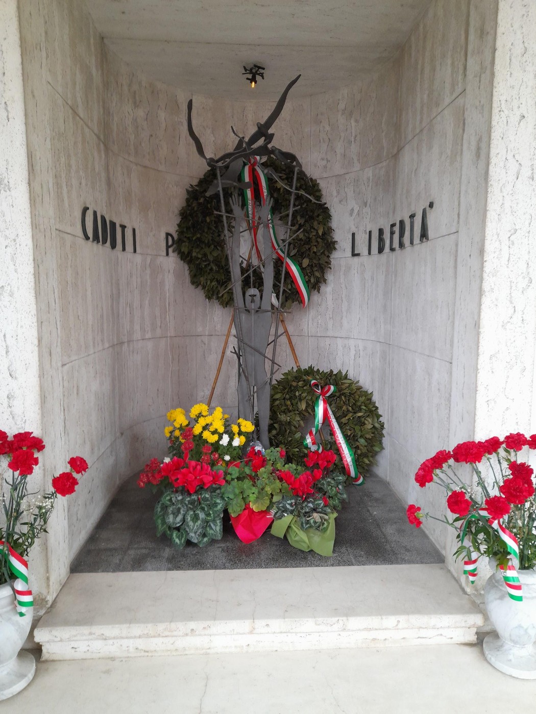 Sacrario dei partigiani, memoriale dedicato ai caduti per la libertà con fiori e decorazioni tricolori.