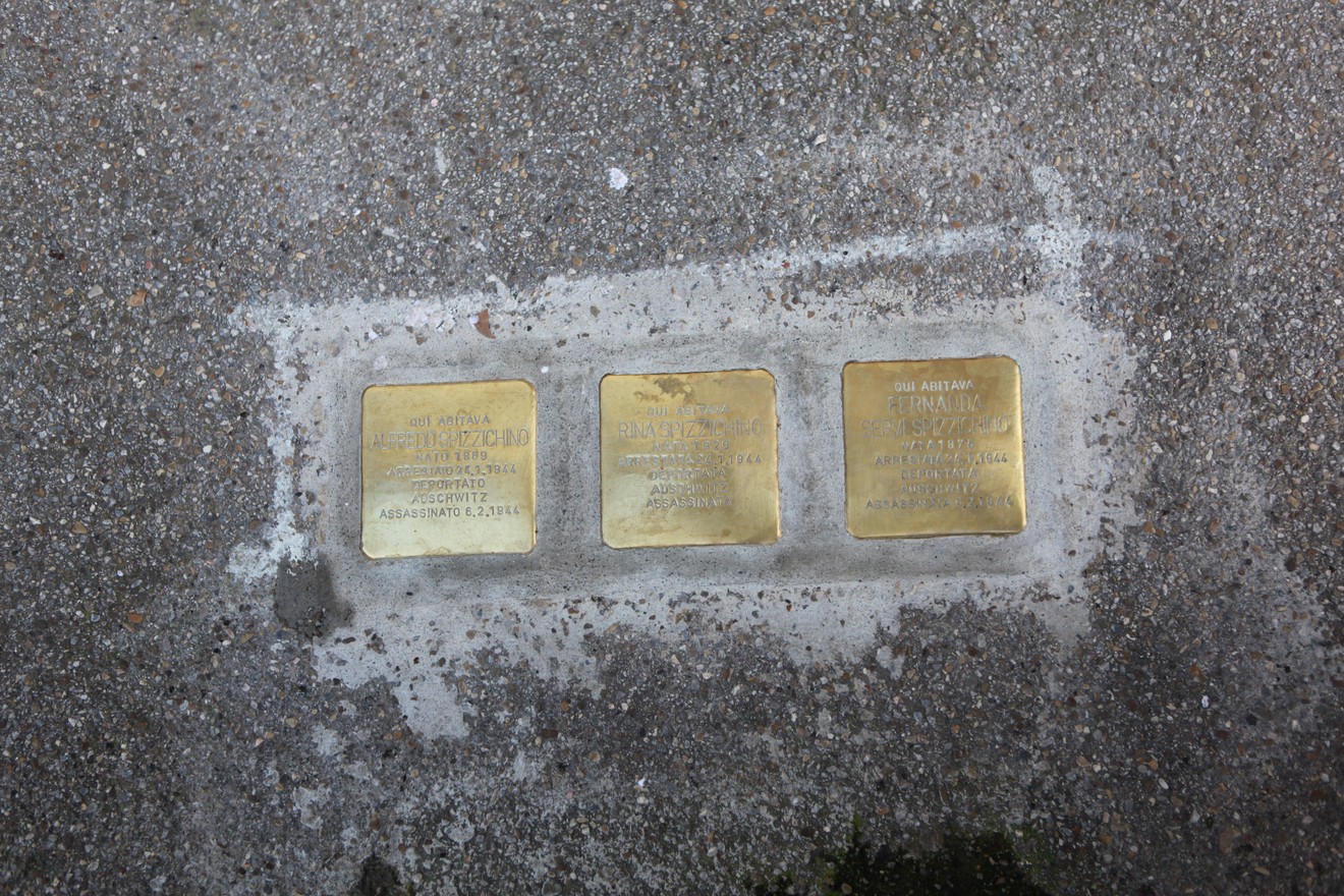 Pietre d'inciampo commemorative dedicate alla famiglia Spizzichino in un contesto urbano.