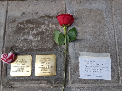 Pietre d'inciampo dedicate a Leo Mariani e Pia Cesana, con un fiore rosso e un messaggio di ricordo.