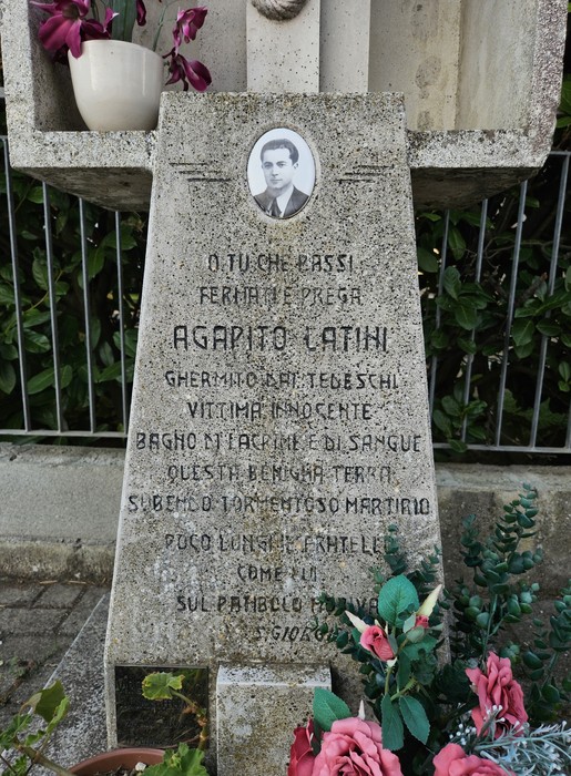 Cippo commemorativo dedicato ad Agapito Latini con iscrizioni e decorazioni floreali.