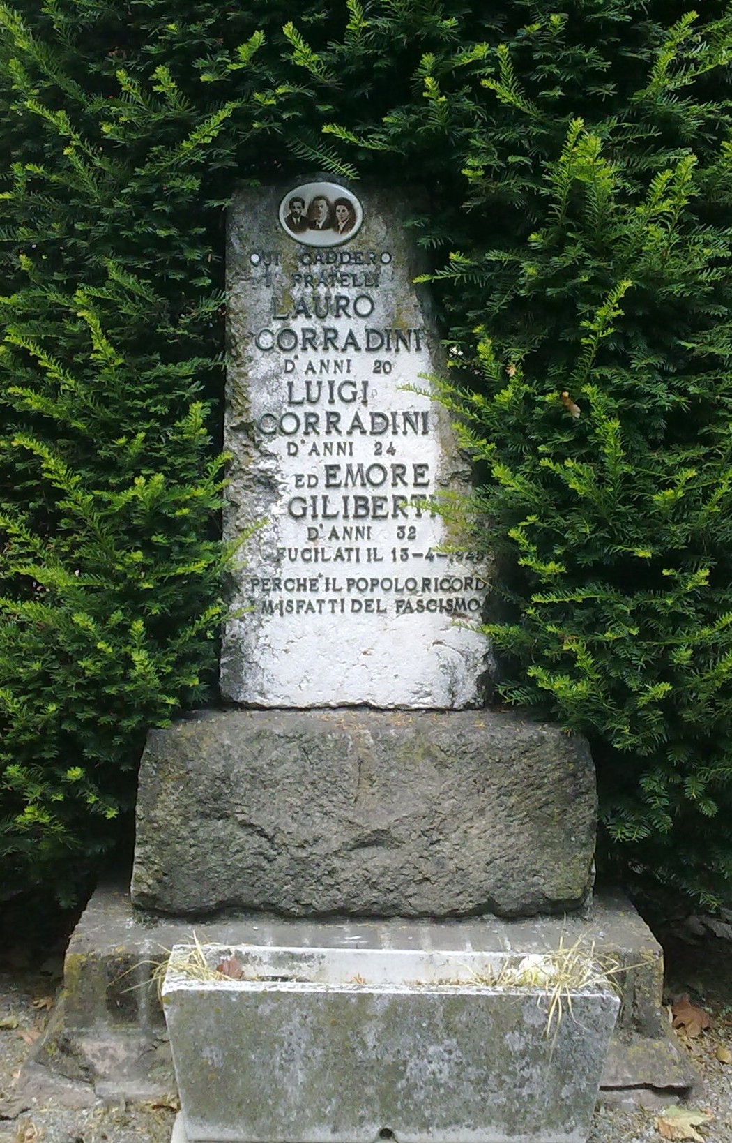Cippo commemorativo in onore di Auro e Luigi Corradini ed Emore Giliberti, situato in un'area verde.