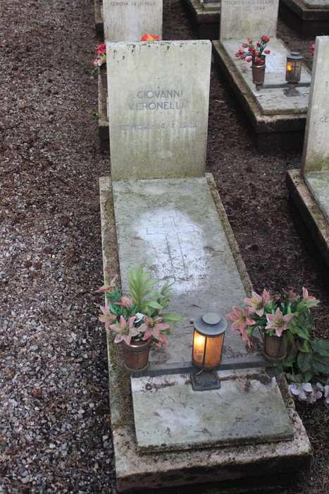Tombe monumentali decorate con fiori, in memoria dei caduti per la Libertà. Atmosfera rispettosa e commemorativa.