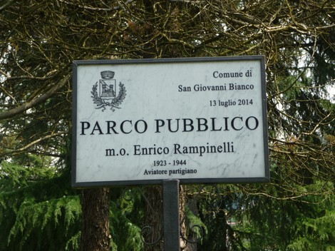 Monumento a Rampinelli, dedicato all'aviatore partigiano Enrico Rampinelli, circondato da alberi e verde.
