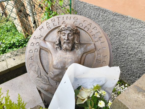 Monumento commemorativo agli uccisi della Botte di Pioppe, rappresentante Cristo crocifisso con omaggi floreali.