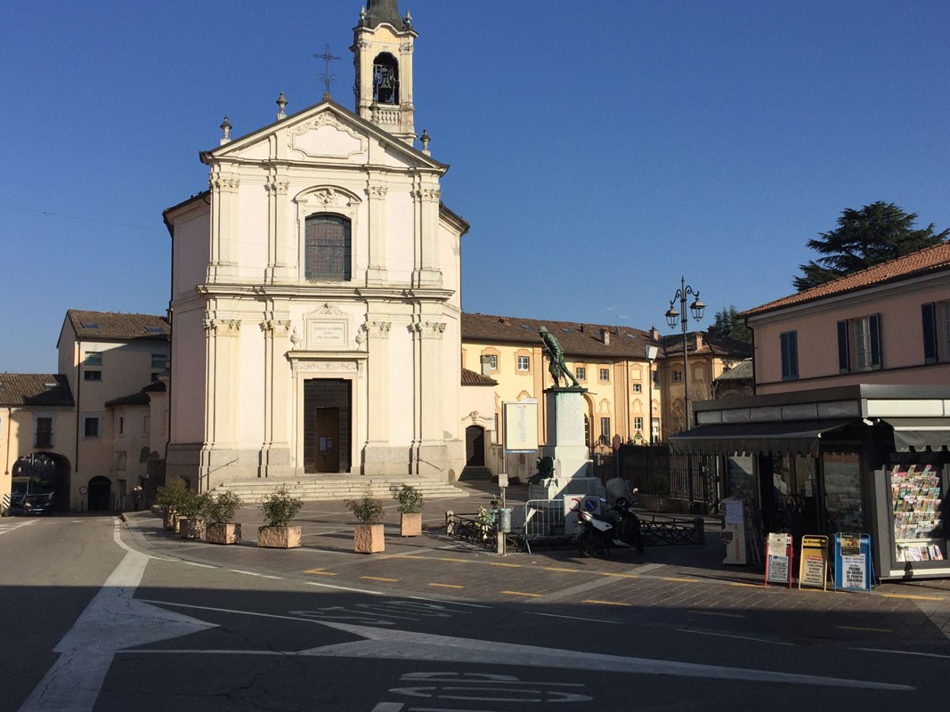 Monumento ai Caduti a Cava Manara, con la chiesa e il centro del paese in sfondo.