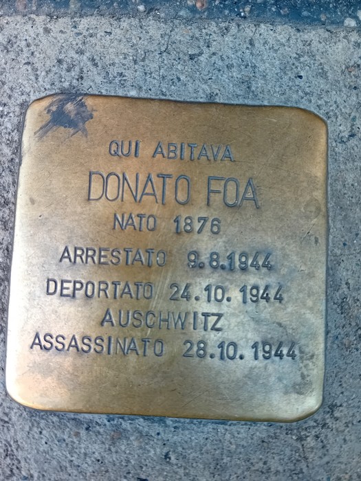 Pietra d'inciampo in ottone incassata nella pavimentazione, con iscrizione dedicata a Donato Foa.