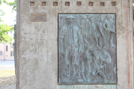 Monumento alla Resistenza con rilievi in bronzo che rappresentano figure storiche e simboliche.