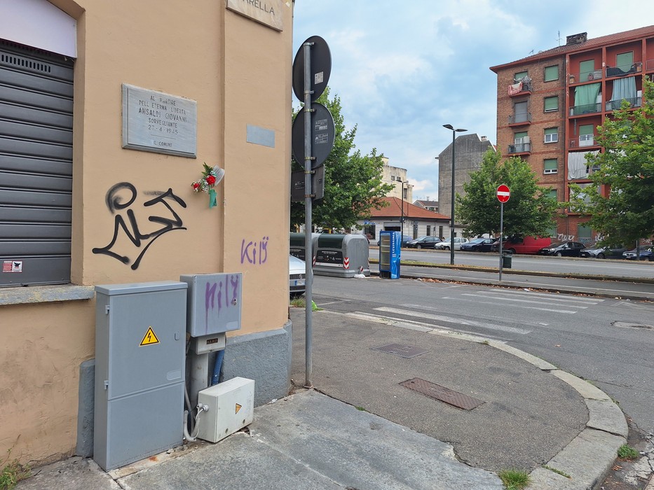 Lapide commemorativa dedicata ad Ansaldi, situata su un edificio all'angolo di una strada urbana.