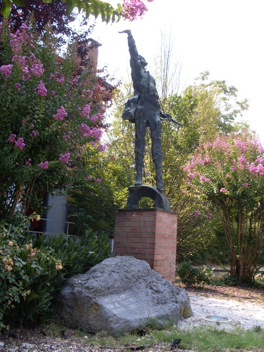 Monumento ai Partigiani: scultura che celebra la resistenza e la lotta per la libertà, circondata da vegetazione.