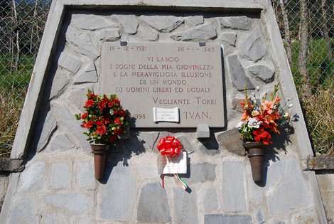 Lapide commemorativa dedicata a Vigilante Torri, con fiori e un nastro, in ricordo della sua vita.