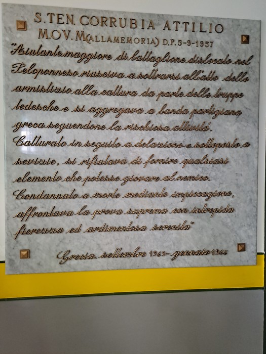 Lapide commemorativa dedicata a Corrubia Attilio, con iscrizioni che ne celebrano la memoria e le gesta.