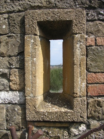 Dettaglio di una finestra del Monumento di Collo Sodo, realizzata in pietra, che offre una vista sul paesaggio circostante.
