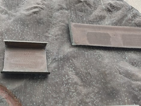 Monumento ai partigiani caduti di Pianoro, con iscrizioni commemorative su una superficie in bronzo.
