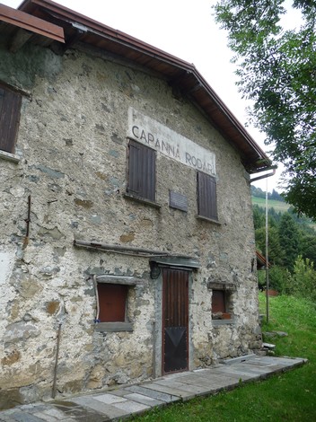 Lapide commemorativa dedicata alla 53a brigata Garibaldi su un muro di pietra in un contesto naturale.