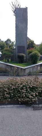 Monumento ai combattenti per la Libertà, circondato da verdure e aiuole fiorite.