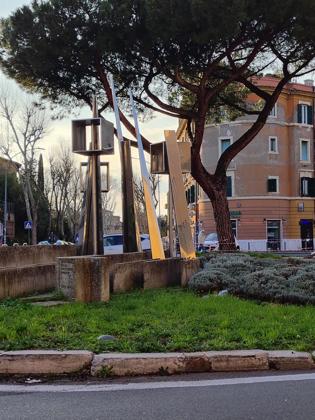 Monumento per il trentennale, con strutture artistiche moderne circondate da alberi e verde.