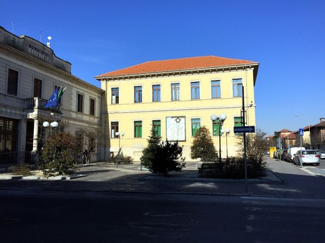 Lapide commemorativa ai caduti, situata a Cassolnovo, con il municipio sullo sfondo.