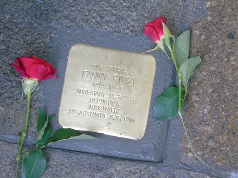 Pietra d'inciampo dedicata a Fanny Finzi, con rose rosse accanto, commemorativa della sua deportazione.