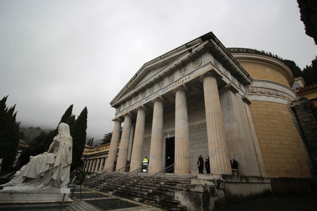 Lapide commemorativa di Gastaldi, con struttura architettonica classica e statue in un ambiente nebbioso.
